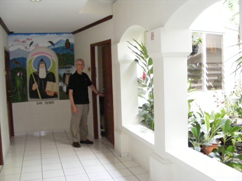 Al standing at the door to our room, with the                   mural of San Benito on one side and the little                  garden courtyard on the other