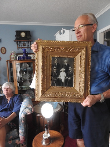 Mark is holding a gold-framed photo of the five surviving children