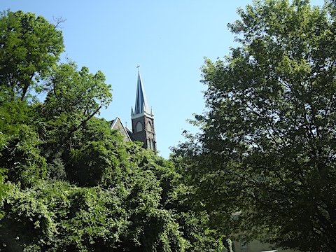 The steple of the church pokes 
           above the hillside trees