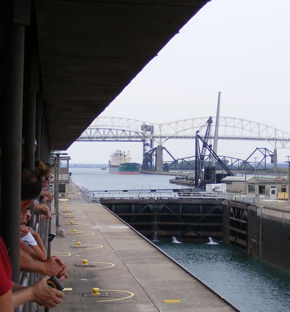 The Chestnut passing below the highway and
               railroad bridges as it approaches the Poe Lock.
               The closed upper gates of the MacArthur Lock are visible.