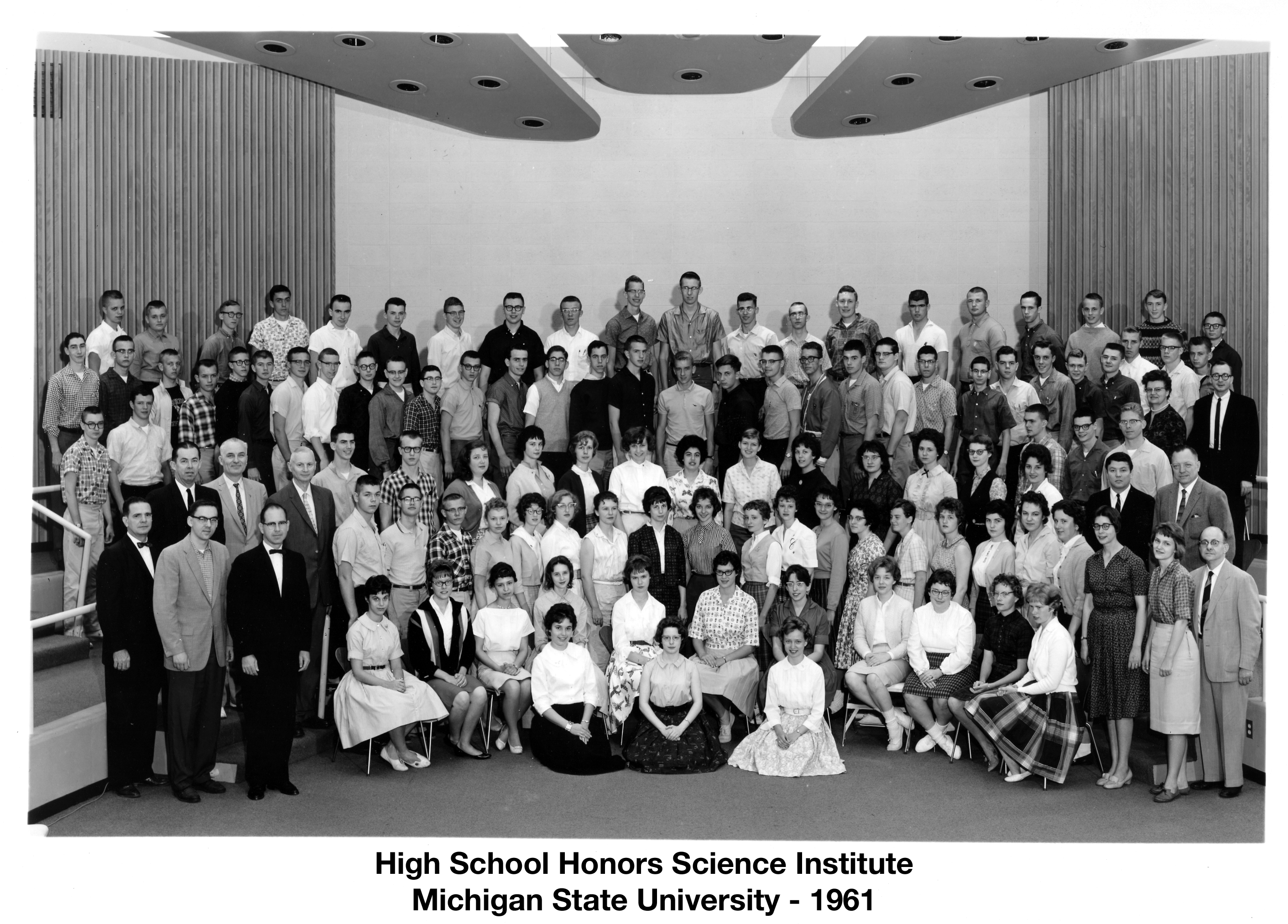 114 students and instructors are arranged in six rows in a large room