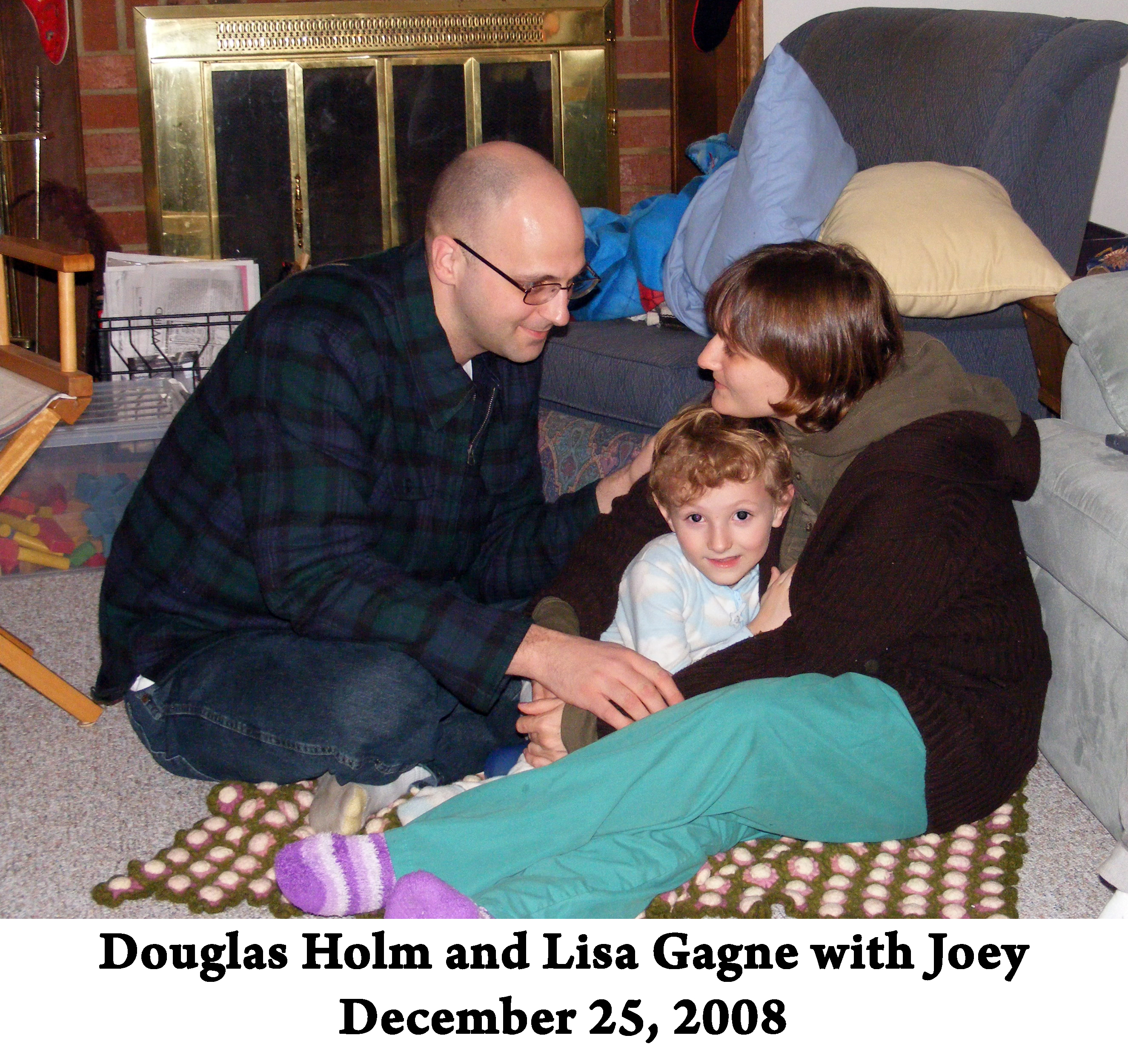 Doug, Lisa, and Joey sitting on the floor in front of our fireplace