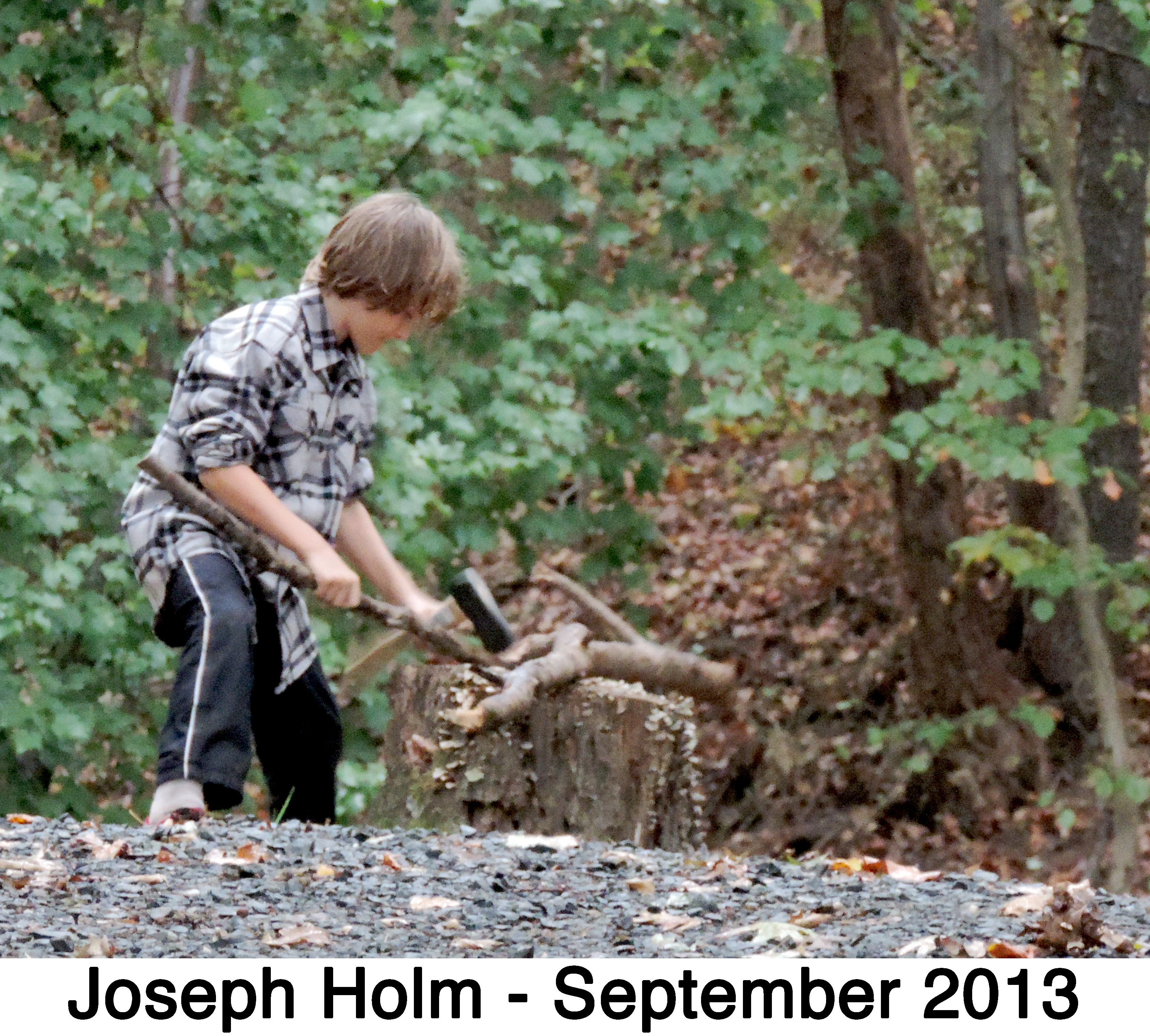 Joseph Holm uses a hatchet to make some firewood for their camp