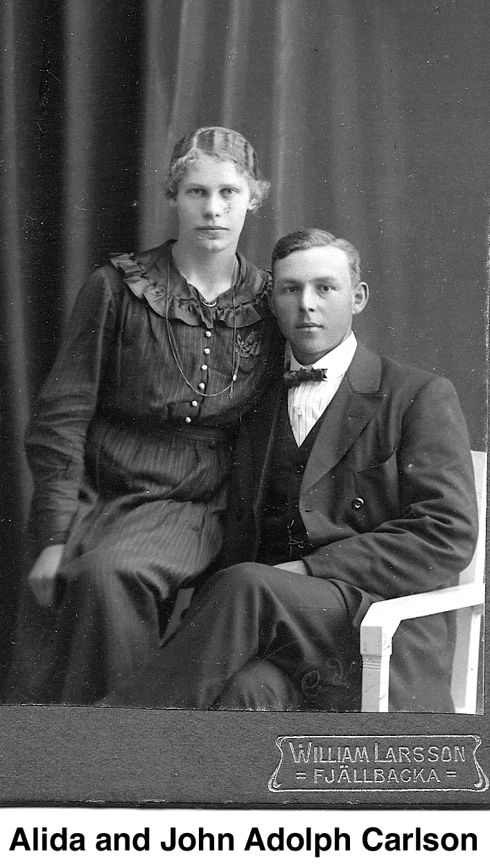 This is a studio photo with her in a dark dress and sitting the 
     arm of the white chair in which he is sitting. He is wearing a suit and a bow tie