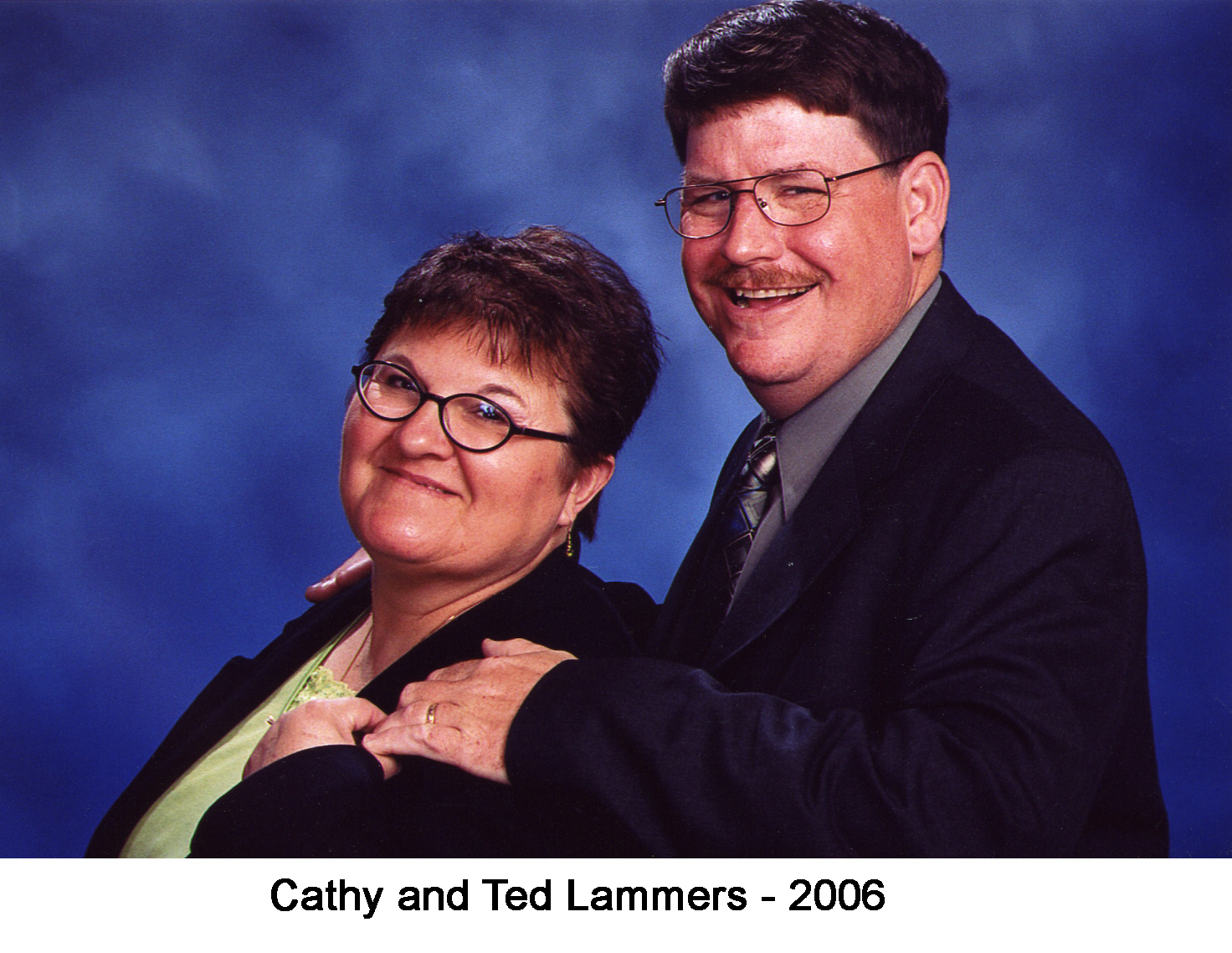 Cathy Baker with Ted Lammers in a studio photo. Ted stands behind her
       with his hand on her shoulder.