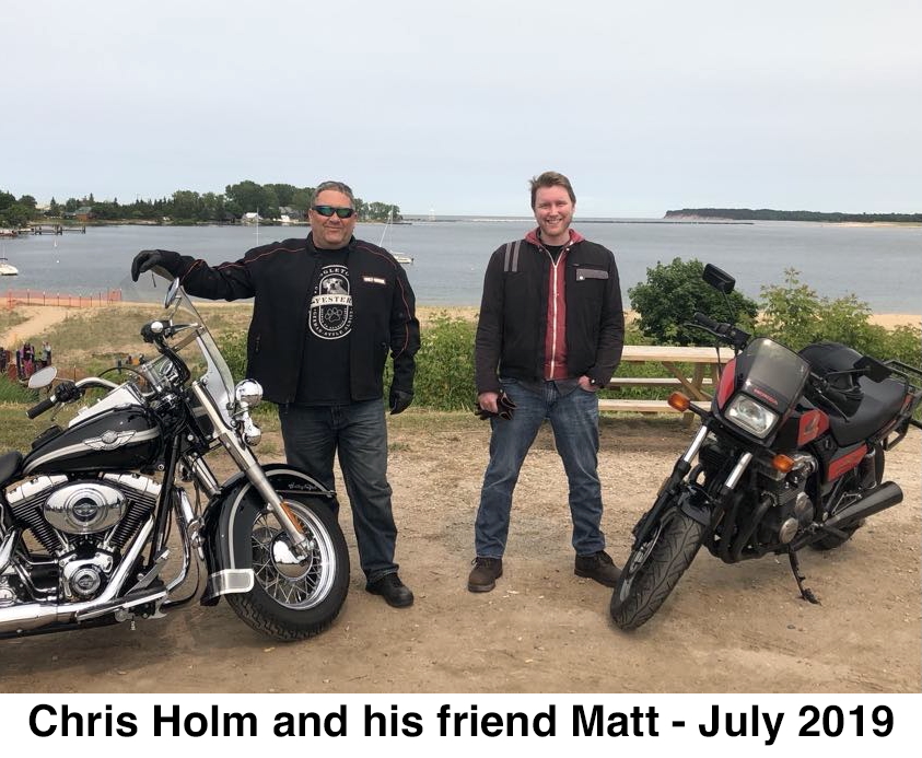Chris and his friend Matt are standing beside their motorcycles in front 
            of the Grand Marais harbor.