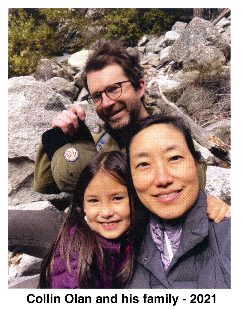 The family is in front of a rocky hillside
