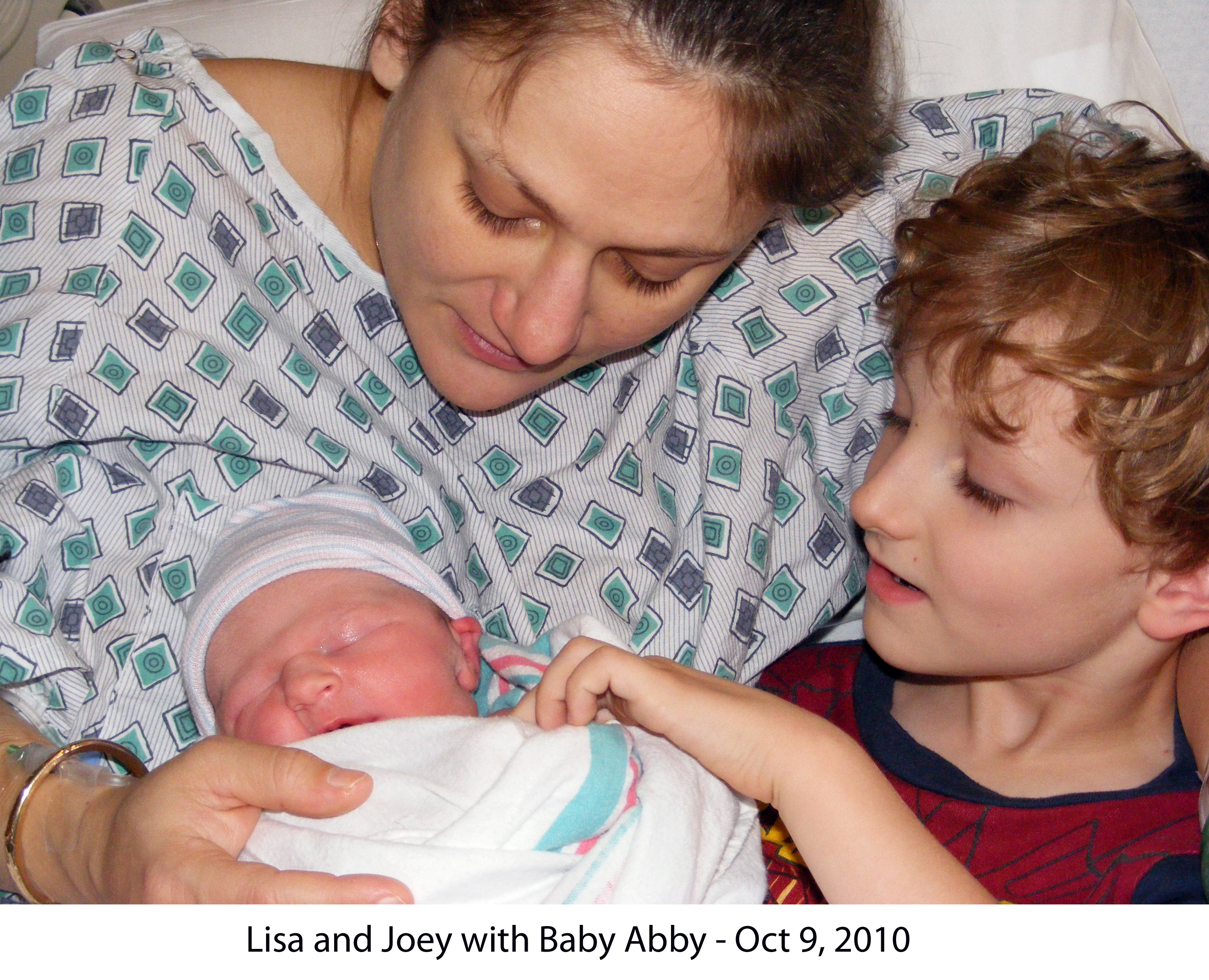 Lisa holding Abby in bed in the medical center where Abby was born. 
     Lisa and Joey are looking at the little girl.