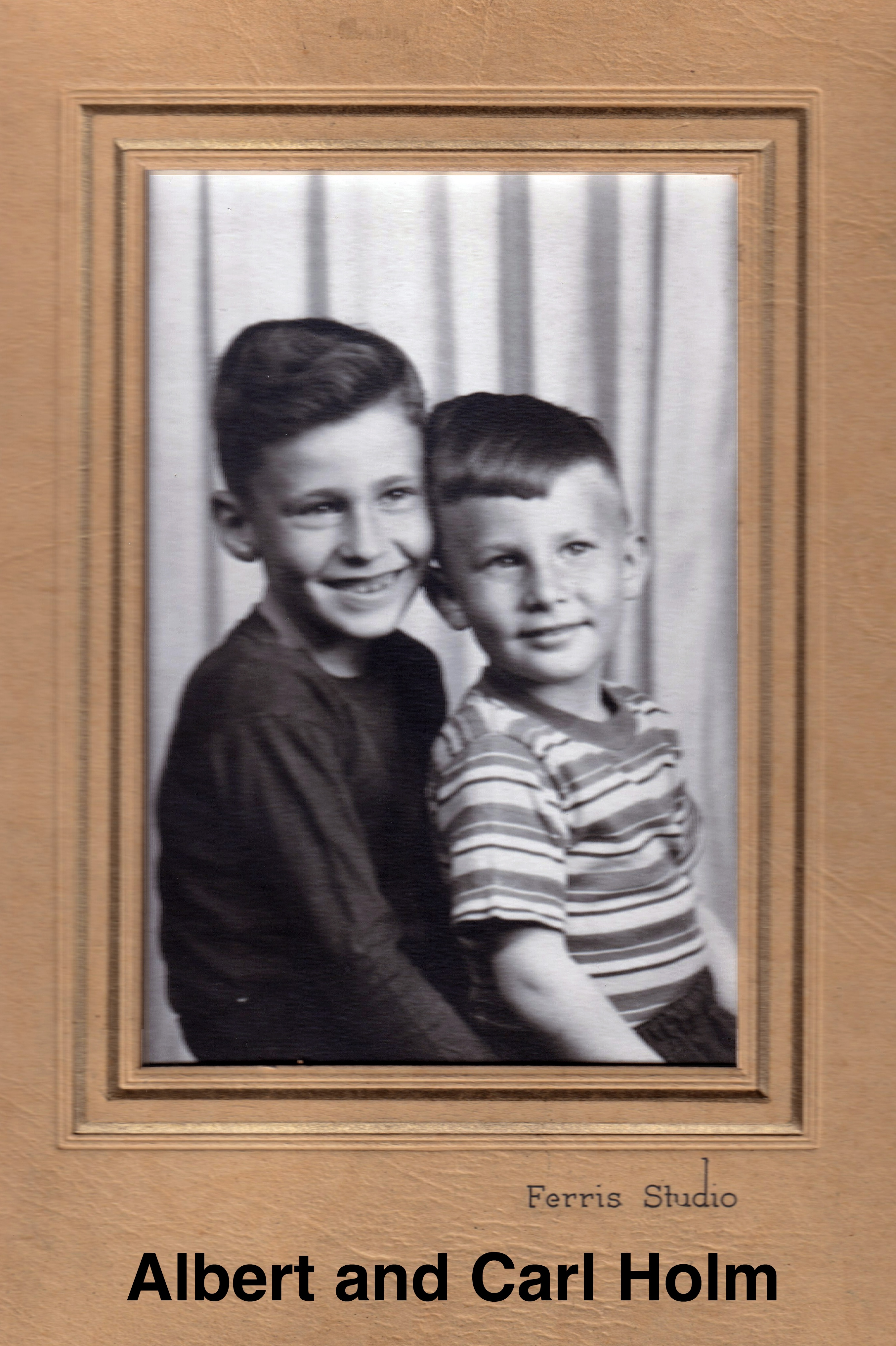 They are sitted with their right sides to the camera. Albert is
       wearing a dark, long-sleaved shirt and Carl is wearing a striped, short-sleaved shirt.