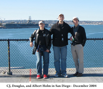 CJ, Doug, Al Holm standing on the aircraft carrier deck with San Diego harbor behind them