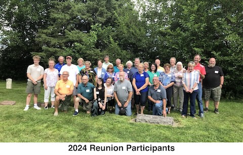 29 participants in the reunipn are standing at the grave of Otto 
           and Caroline Holm