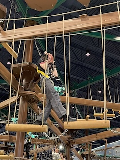 Abigail Holm standing on a trapeze of the ropes course in the Great Wolf Lodge