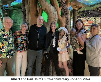 Albert and Gail Holm are lined up with their children and two grandchildren
           in front of an artificial tree at a Great Wolf Lodge