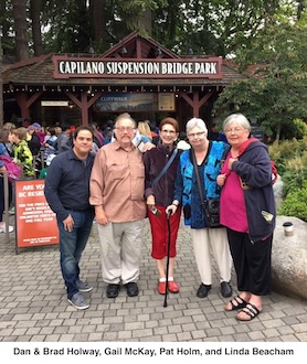 The five are standing in front of a sign for the Capilano Suspension Bridge Park