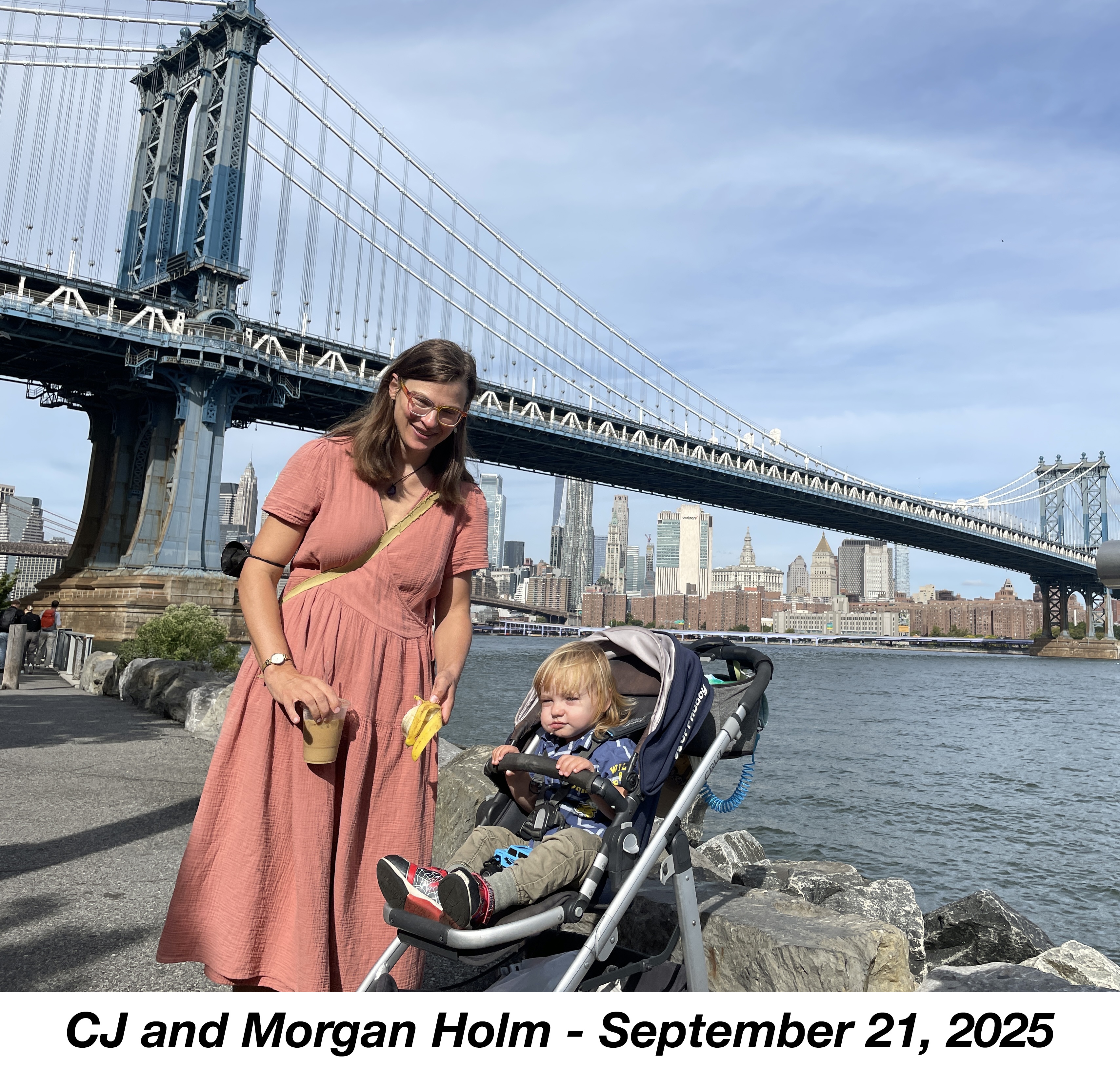 Morgan is in his stroller by the East River with the Manhattan Bridge in the 
              background. CJ is holding his cup and a banana peel.