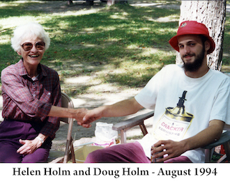 Helen Holm and Douglas Holm sitting in front of trees and holding hands