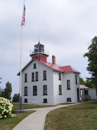 The light house is a short tower
               on top of the two-story living quarters.
               The building is white with a red roof.