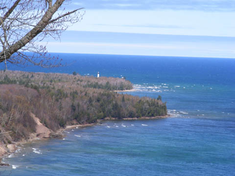 View from the Log Slide Overlook toward the Au Sable Light Station.           The sky and lake are deep blue but the wind is blowing up whitecaps