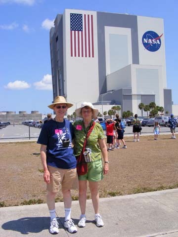 Al and Gail Holm standing in front of, but still at a distance from the 525-foot tall Vertical Assembly Building
