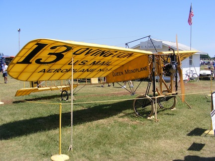 The yellow monoplane is sitting on grass.