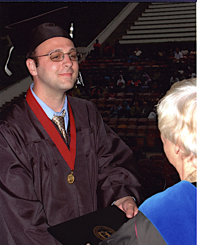 Doug receives his folder at the graduation ceremony
