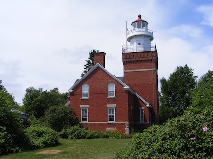 The photo was taken from the side of the
               lighthouse. The square tower is attached
               to the front of the residence. Both are
               painted red.