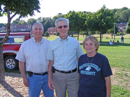 Carl, Al and Ruth Ann stand in the shade of a 
               tree. A grassy field is behind them.