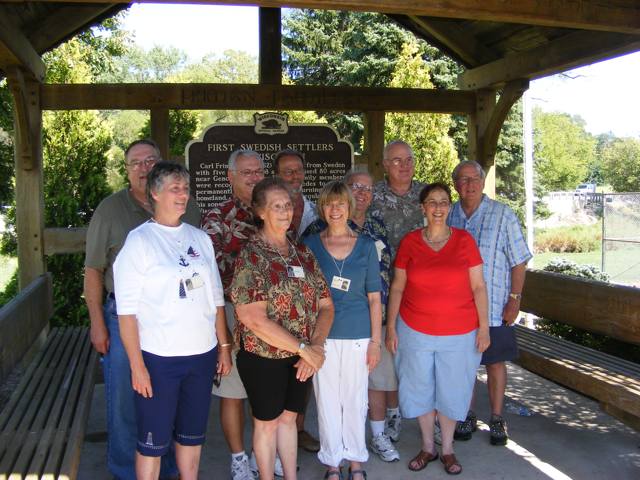Ten members of the 8th grade class of 1961
               pose in the shelter dedicated to the First Swedish
               Settlers in Wisconsin. 