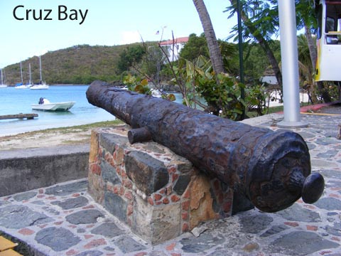 An antique cannon in the park
       near the ferry dock points out across the harbor at Cruz Bay.