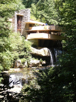 Cantilevered terraces jut out over
               the two small falls below. Tree branches
               frame the image.