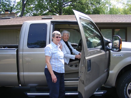 92-year-old Millie sits in the
                   passenger seat while Gail stands
                   alongside the open door