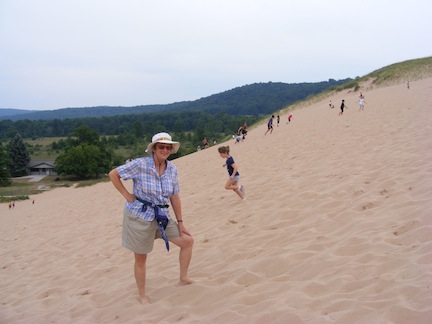 Gail is standing with one foot up the 
               slope  of fine sand. Behind her a young girl
               is running down the hill.