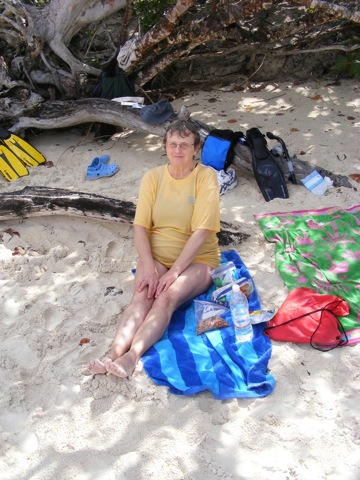 Gail sitting on her beach 
     towel at the edge of the Trunk Bay beach