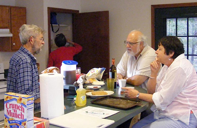 Bill Bower talks with Bob Zink and Lolly Bower while preparing dinner