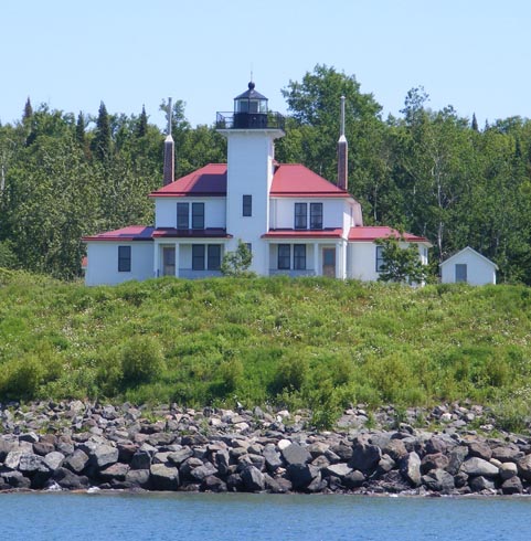 The photo was taken from a boat on Lake
                  Superior. The square tower for the light
                  is build into the residence for the 
                  keeper and his assistant. The walls
                  are white and the roof of the house is
                  red.