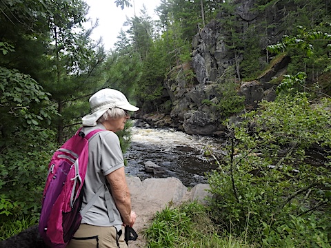 Gail is looking out at the rapids and cliffs on the other side of the river