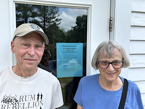 We are smiling in front of the town hall door that has a blue flier 
             in the window